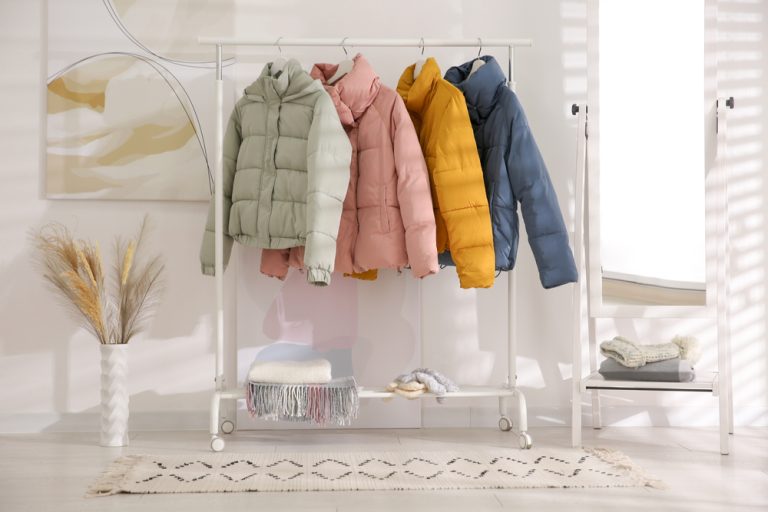 different,warm,jackets,on,rack,in,stylish,room,interior