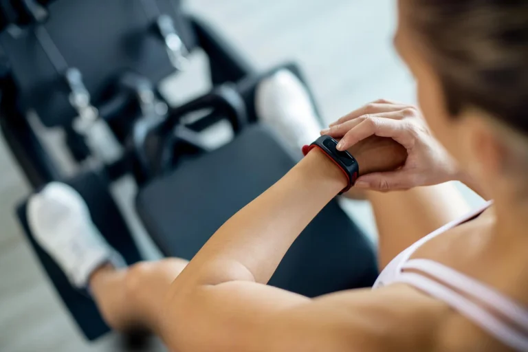 closeup sportswoman using fitness tracker while working out gym (1)