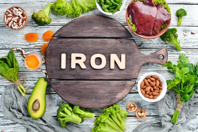 food containing natural iron fe liver avocado broccoli spinach parsley beans nuts white wooden background top view