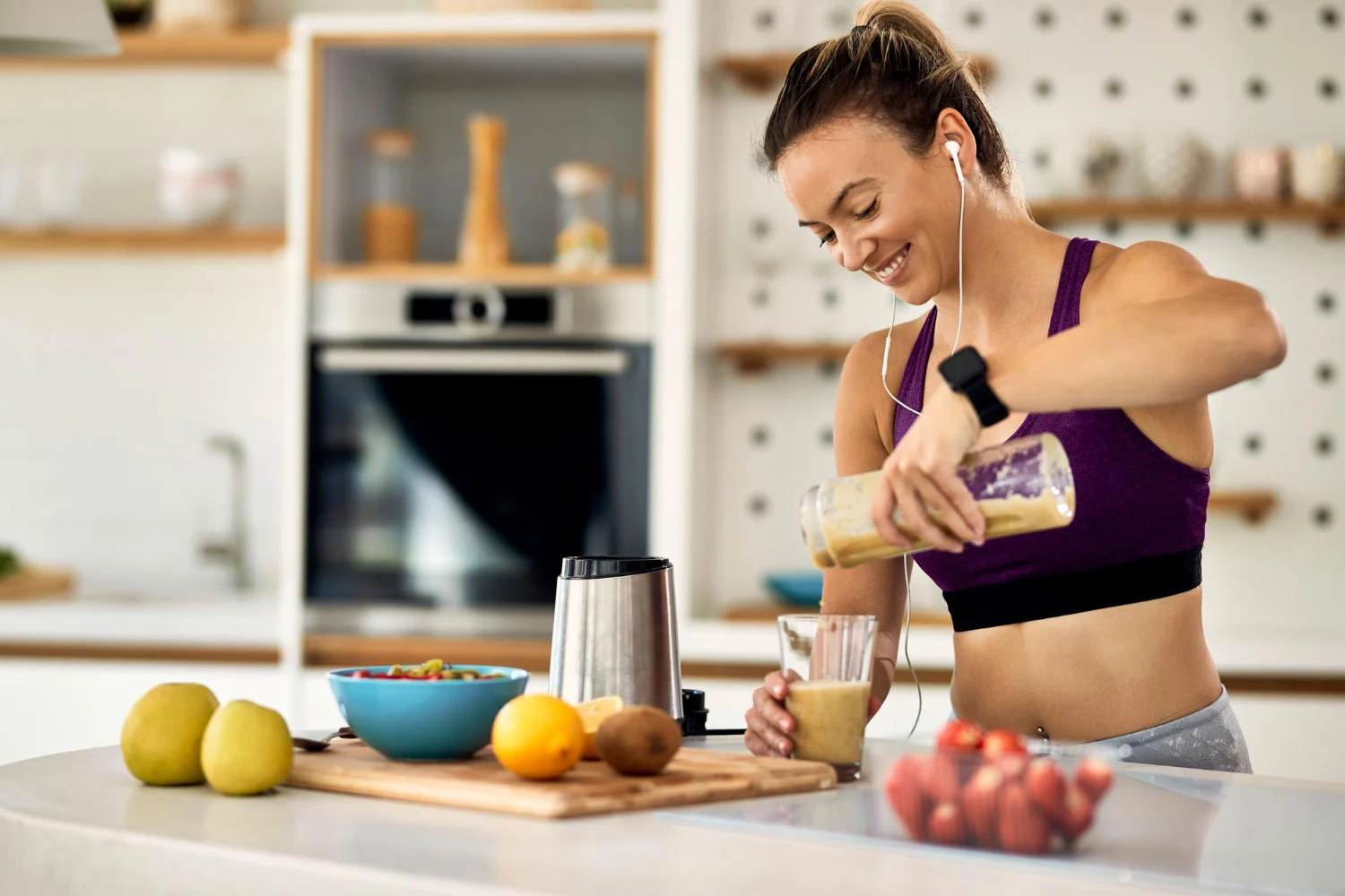 young happy athletic woman having fruit smoothie breakfast kitchen